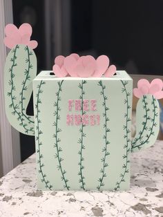 a cactus shaped box with pink flowers on it