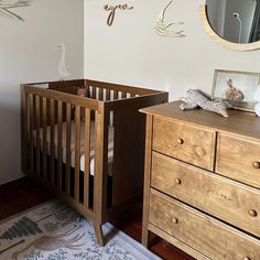 a baby crib in the corner of a room next to a dresser and mirror