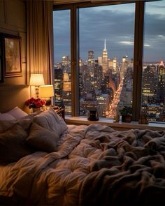 a bedroom with a view of the city at night