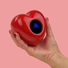 a hand holding a red heart shaped object