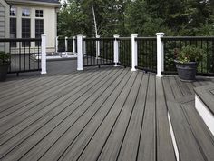 a wooden deck with white posts and black railing