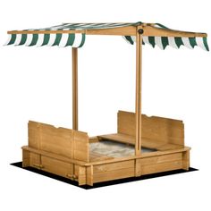 a wooden bed with green and white striped awnings on the top over it