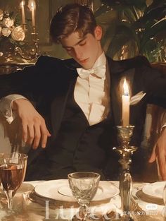 a young man in a tuxedo sitting at a table with wine glasses and silverware