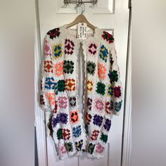 a crocheted sweater hanging on a door