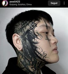 a man with tattoos on his face and neck