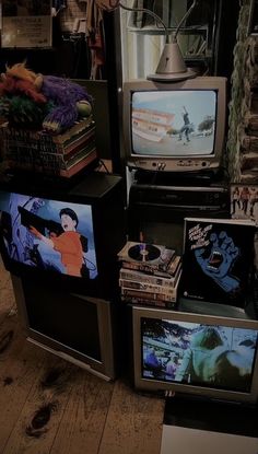 several televisions are stacked on top of each other in front of a pile of books