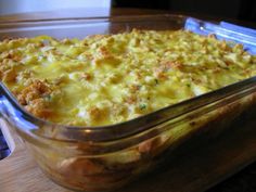 a casserole dish with meat and cheese in it sitting on a wooden table