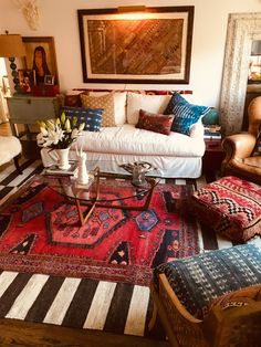 a living room filled with lots of furniture and rugs on top of a wooden floor