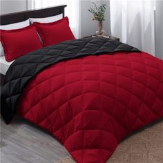 a red and black comforter on a bed