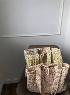 four bags sitting on top of a chair in front of a wall with white trim