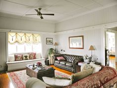 a living room filled with furniture and a ceiling fan