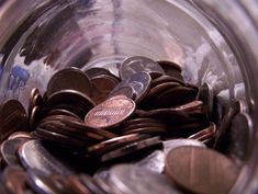 a glass jar filled with lots of coins