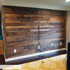 a room with wood paneling and wires on the wall in front of an area rug