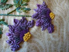 two purple and yellow embroidered flowers on fabric