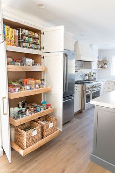 a kitchen with white cabinets and wooden shelves filled with food items on top of them