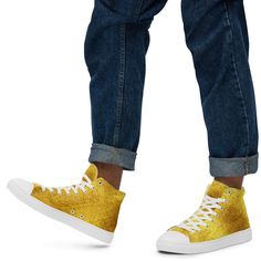 a person standing with their legs crossed wearing yellow sneakers