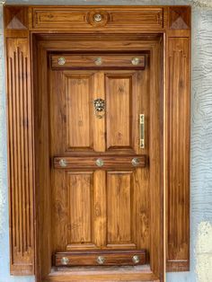 a wooden door is shown in front of a stucco wall with an iron knocker