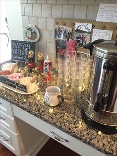 a kitchen counter topped with lots of glasses and food next to an electric coffee maker