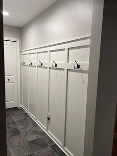 a row of white lockers sitting next to each other in a room with tile flooring