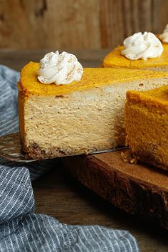 a slice of pumpkin cheesecake on a wooden cutting board with a piece taken out