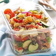 two plastic containers filled with pasta salad on top of a blue towel