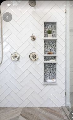 a white tiled shower with shelves on the wall