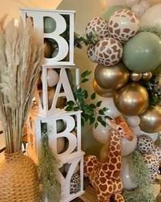 a giraffe, balloon and baby blocks are on display