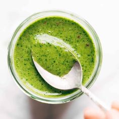 a spoon in a jar filled with green liquid