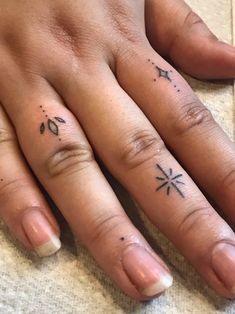 two people with matching tattoos on their fingers, one has an arrow and the other has a cross