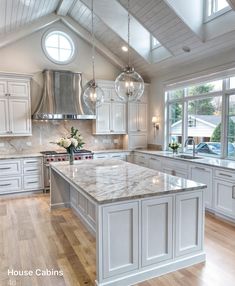 a large kitchen with white cabinets and marble counter tops