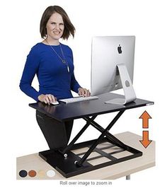 a woman sitting at a computer desk with an arrow pointing to the monitor and keyboard