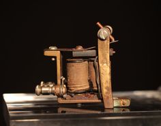 an old fashioned sewing machine sitting on top of a metal table with the needle still in it's holder