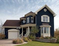 a large blue house with white trim and lots of windows on the front of it