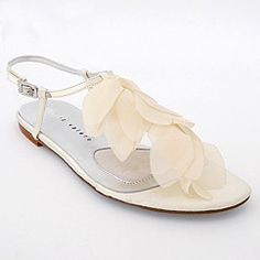 a pair of white shoes with flowers on the toe and heel, all in satin material