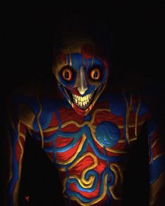 a man with painted body and face in the dark