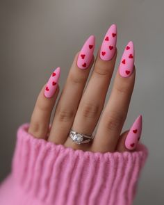 A soft matte pink base is complemented by tiny red hearts placed across the nails. The long stiletto shape enhances the design’s bold and feminine appeal, perfect for Valentine’s Day celebrations. This minimalist yet striking look is a great example of Valentine’s Day red nail trends. Matte Pink Nails, Heart Place, Matte Pink