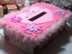 a pink box with flowers and hearts on the inside sitting on top of a table