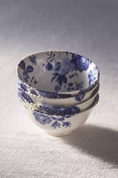 three blue and white bowls are stacked on top of each other in the shape of flowers