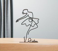 a wire sculpture of a woman in a dress with the name salina on it