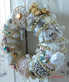 a close up of a wreath on a door with pearls and other things around it