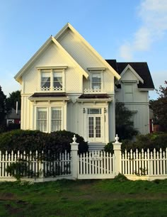 a white house with a picket fence around it