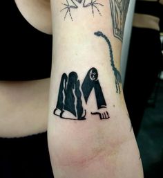 a woman with a tattoo on her arm that has an image of two people sitting next to each other