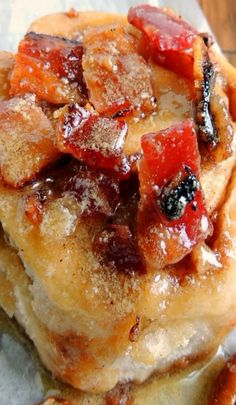 a stack of pancakes covered in fruit and powdered sugar