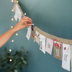 a woman is holding her cell phone up to the clothes line that has been decorated with red and white polka dots