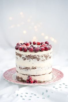 a cake with white frosting and berries on top