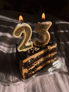 a birthday cake with two candles in the shape of the number twenty three on it