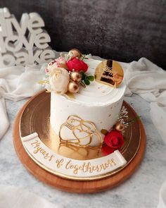 a white and gold wedding cake sitting on top of a plate