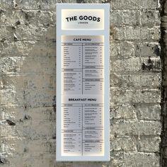 a menu hanging on the side of a brick wall