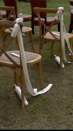 several chairs with white ribbons tied to them