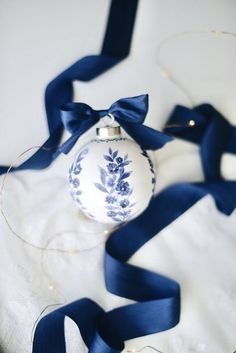 a blue and white ornament with a ribbon around it